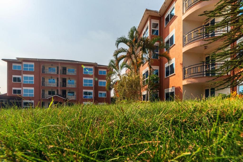 an apartment building with tall grass in front of it at A'lure Hotel & Residences in Kampala