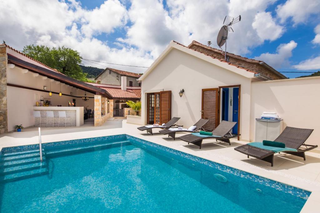a villa with a swimming pool and a house at Villa Jasmine in Dol