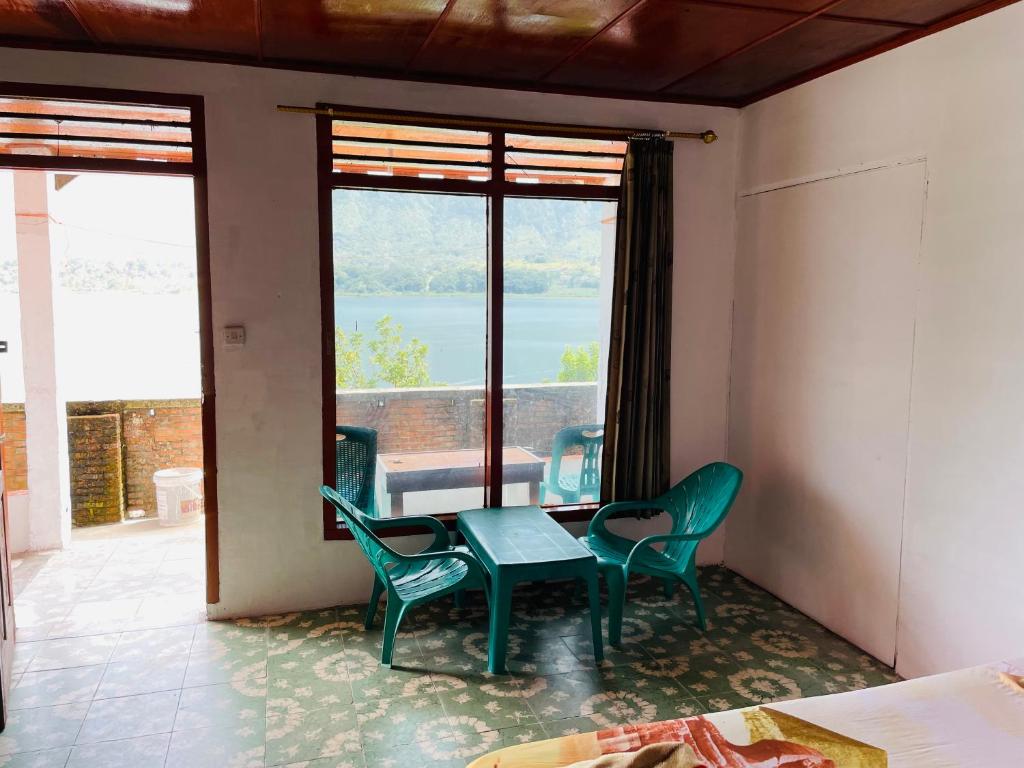 a room with a table and chairs and a window at Elsina guest house in Tuk Tuk