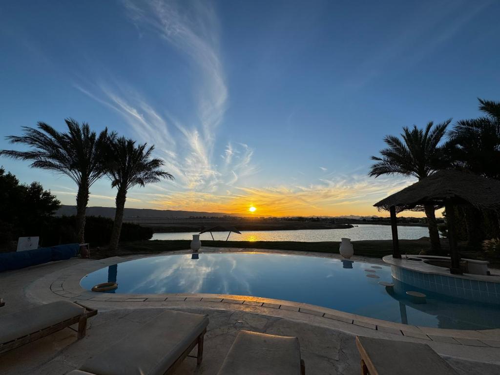 una piscina con puesta de sol en el fondo en Sunset Villa in El Gouna with Private Heated Pool en Hurghada