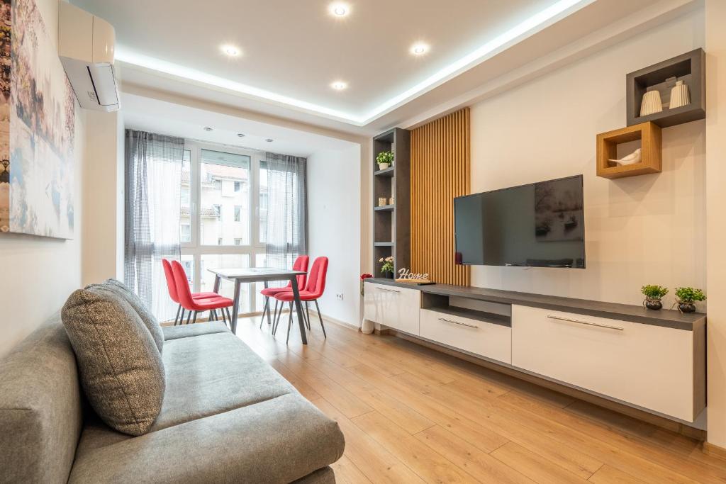 a living room with a couch and a tv and a table at Zenith Apartment in Sofia