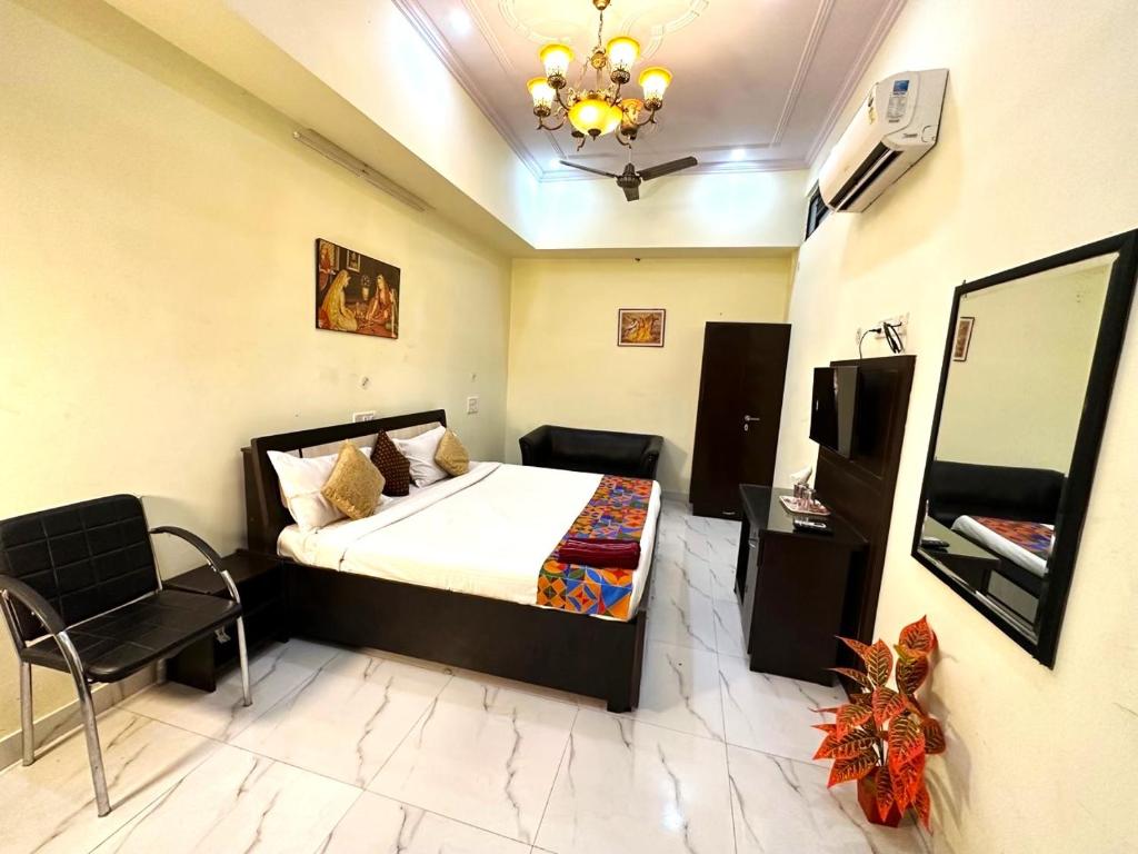- une chambre avec un lit et une chaise dans l'établissement Jaipur Heritage Haveli, à Jaipur