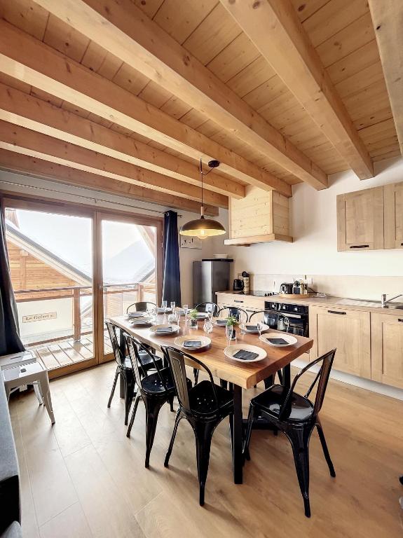 une salle à manger avec une table et des chaises dans une cuisine dans l'établissement Chalet Le Charbonnel, à La Toussuire