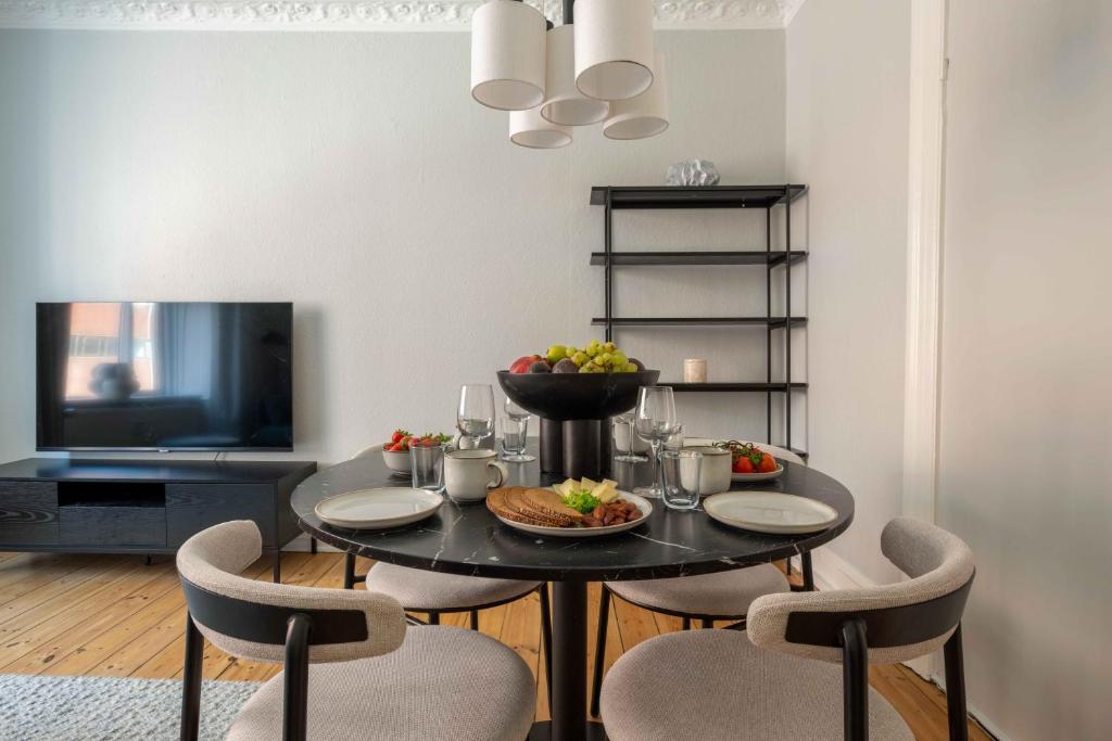 comedor con mesa negra y sillas en Lovely Flat in Vibrant Area, en Copenhague
