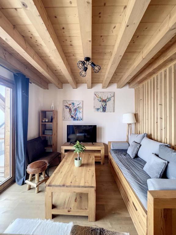 un salon avec un canapé et une table dans l'établissement Chalet Le Gebroulaz, à La Toussuire