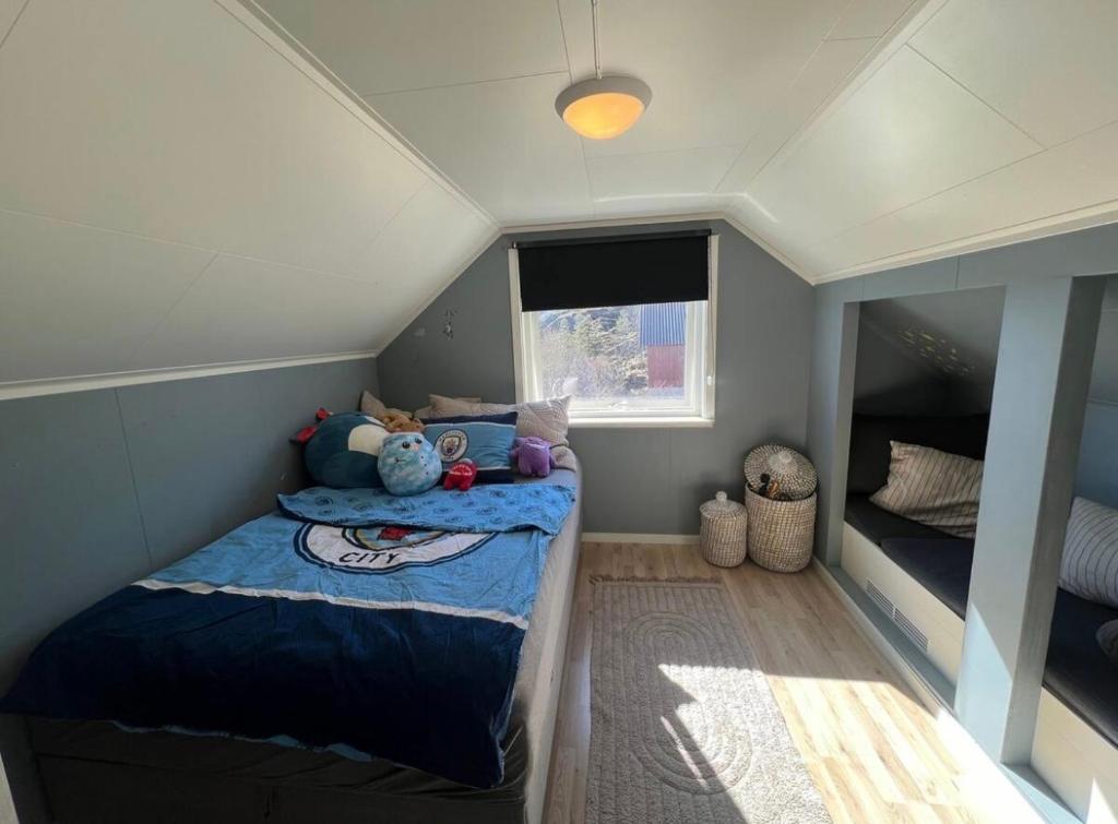 a small bedroom with a bed and a window at House in Ballstad in Lofoten in Skotnes