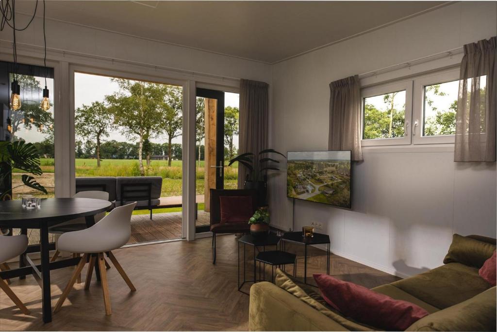 een woonkamer met een bank en een tafel bij Panorama lodge with wellness and hottub 2 p. in Rijssen