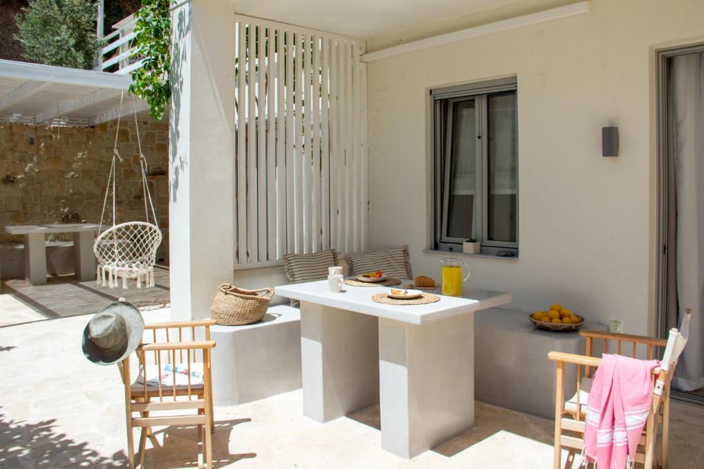 eine Terrasse mit einem weißen Tisch und 2 Stühlen in der Unterkunft Kynthia Suite - Escape to Seaside Makry Gialos in Makry Gialos