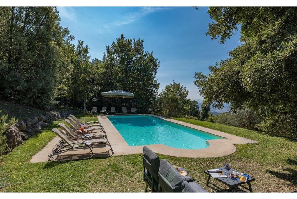 - une piscine avec des chaises longues et un parasol dans l'établissement Villa Linchiano, à Gambassi Terme
