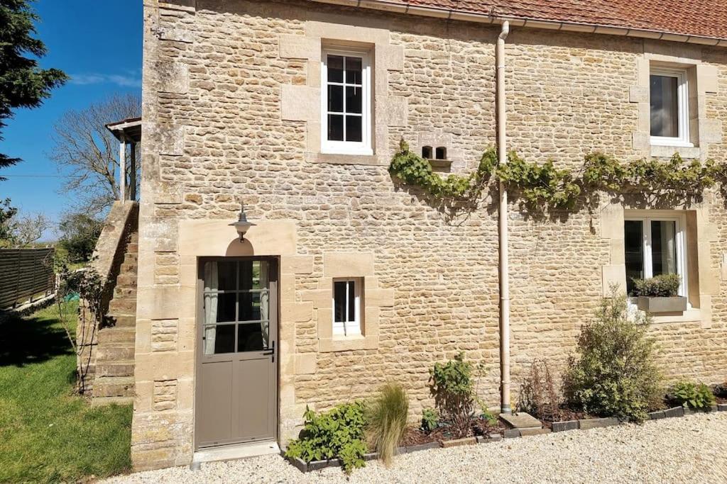 - un bâtiment en briques avec une porte devant dans l'établissement L'Insouciant, à Graye-sur-Mer