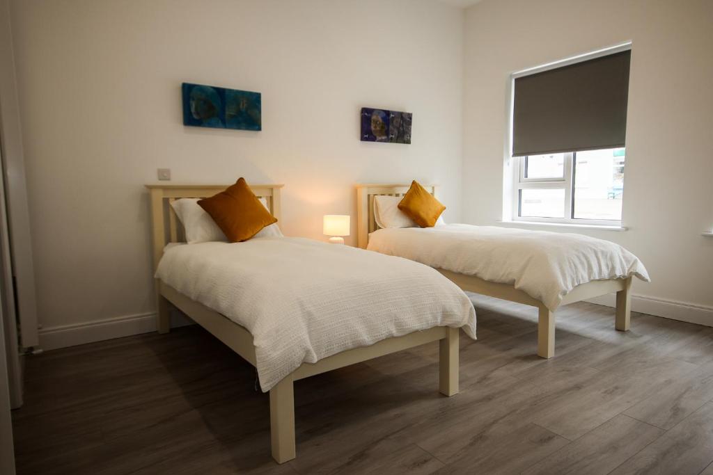 a bedroom with two beds and a window at Carrick Gate in Carrick