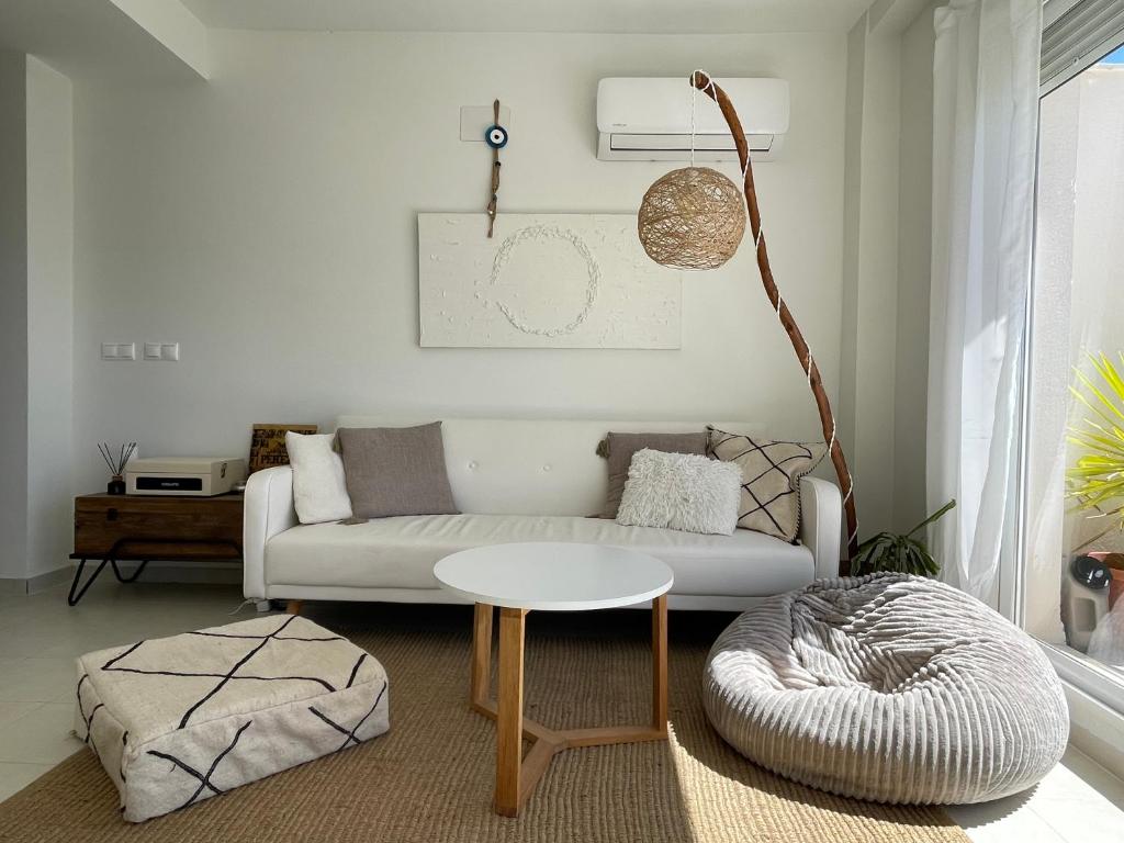 un soggiorno con un divano bianco e un tavolo di Ático duplex Do It Mediterranean a Vinarós