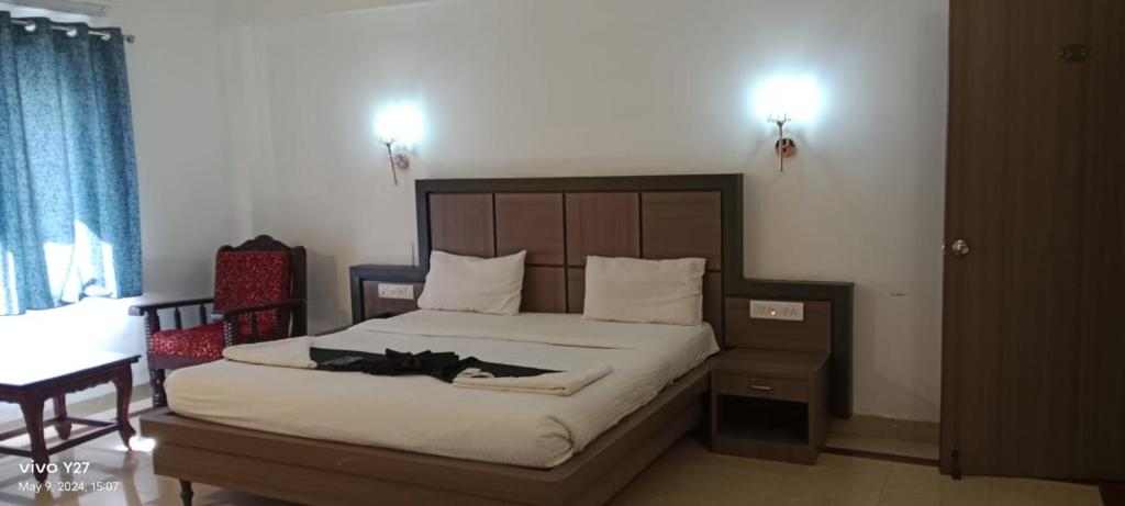 1 dormitorio con 1 cama grande y cabecero de madera en Mount Heera Hotel-Alandur en Chennai