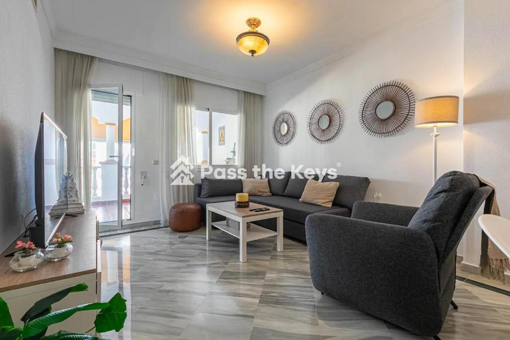 ein Wohnzimmer mit einem Sofa und einem Tisch in der Unterkunft Pass the Keys Apt family friendly in Marbella