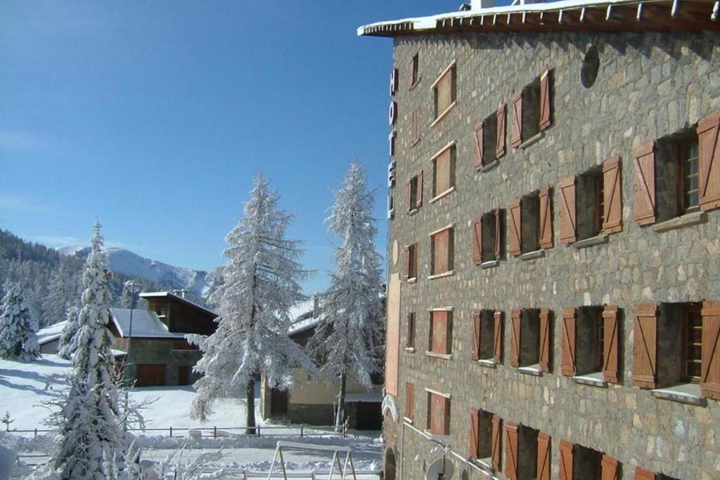 un edificio nella neve con alberi innevati di Le Chastellan Twin roomChambre Twin a Péone