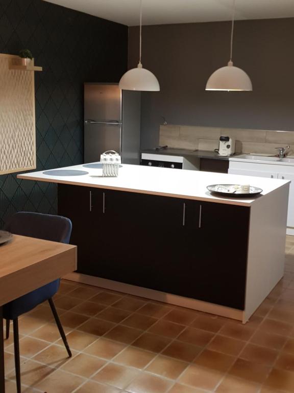 a kitchen with a white counter and a refrigerator at Maison vacances vendee in Saint-Étienne-du-Bois
