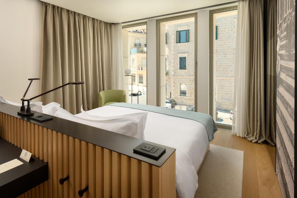 una camera d'albergo con un letto e una grande finestra di Hotel Ambasador a Spalato (Split)