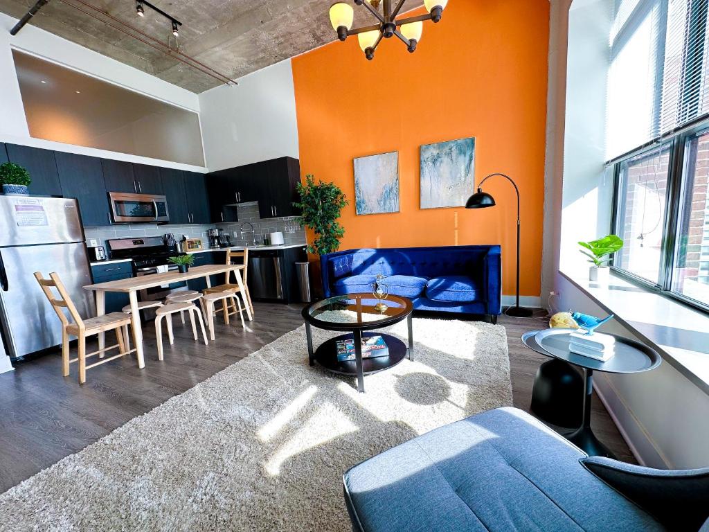 een woonkamer met een blauwe bank en een keuken bij McCormick 2Br/2Ba family unit for up to 6 guests with Optional Parking & Gym access in Chicago