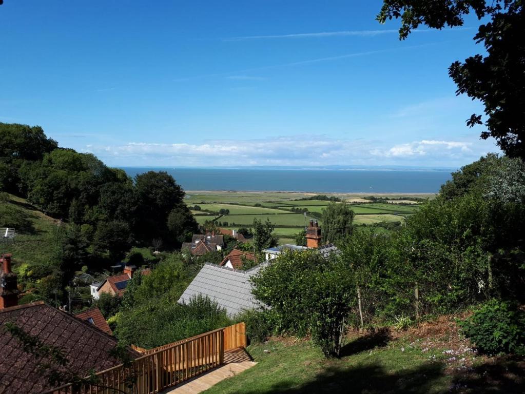 a view of a village with the ocean in the background at West Wind in Porlock