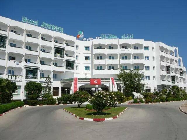 a large white building with a street in front of it at Hotel Jinene Resort in Sousse