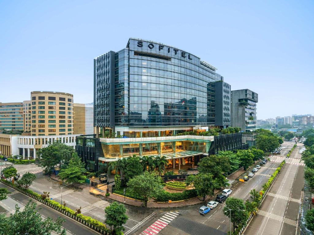 un edificio alto con un cartel en una ciudad en Sofitel Mumbai BKC, en Bombay