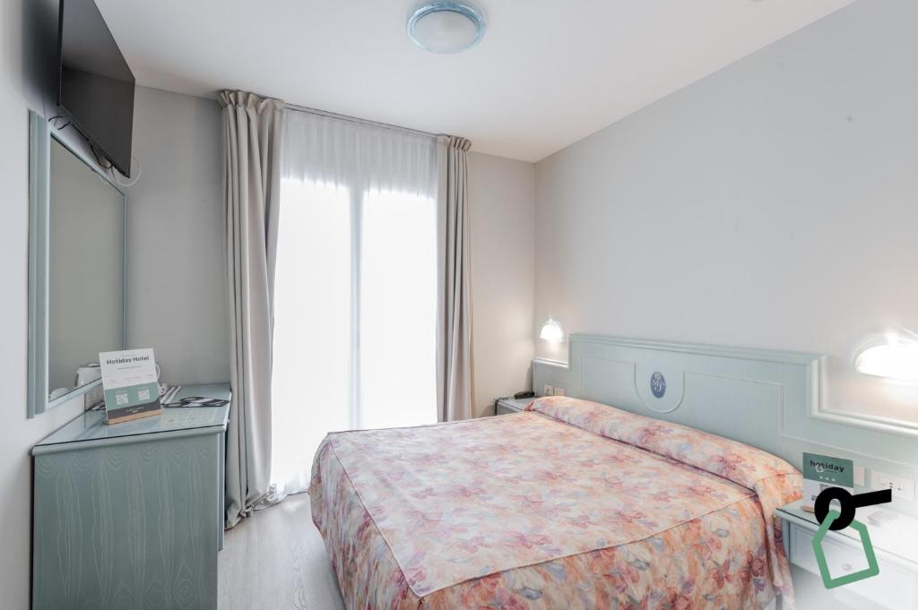 a hotel room with a bed and a large window at HOTIDAY Hotel Jesolo Lido in Lido di Jesolo