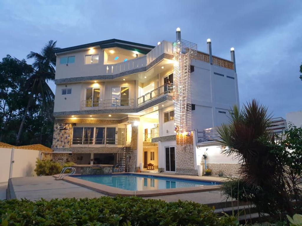 a large house with a swimming pool in front of it at Elicon Suites in Tagbilaran City