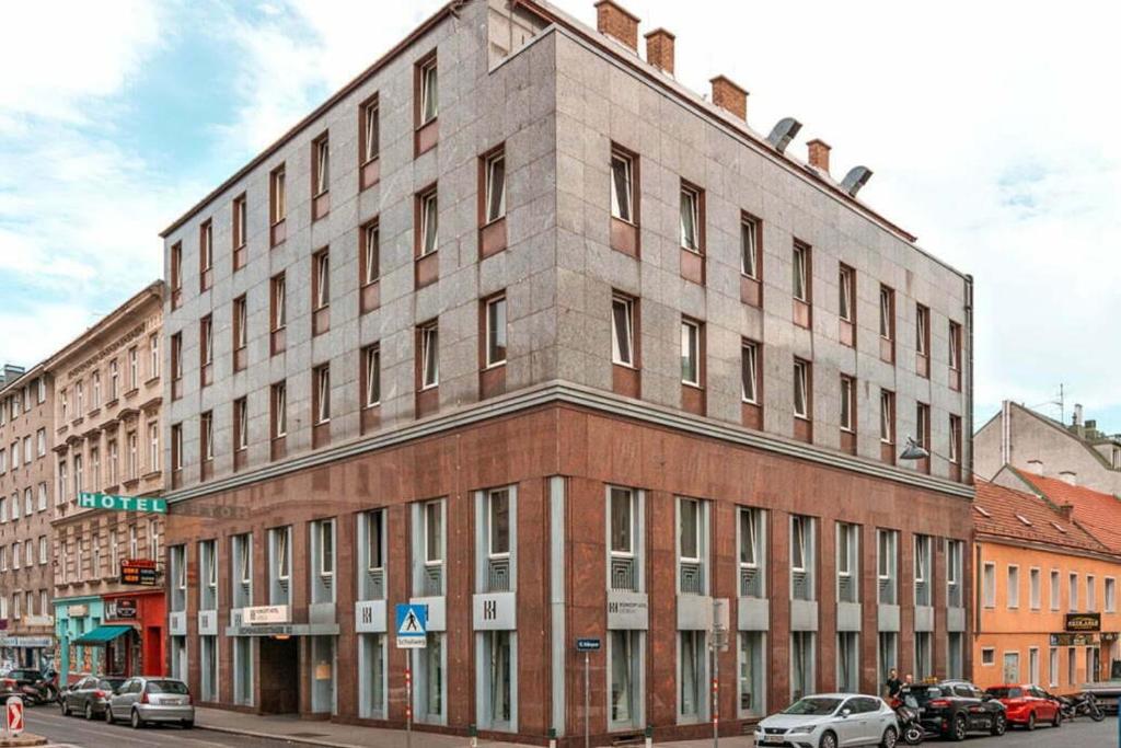 een groot bakstenen gebouw in een stadsstraat bij Hotel George Vienna in Wenen