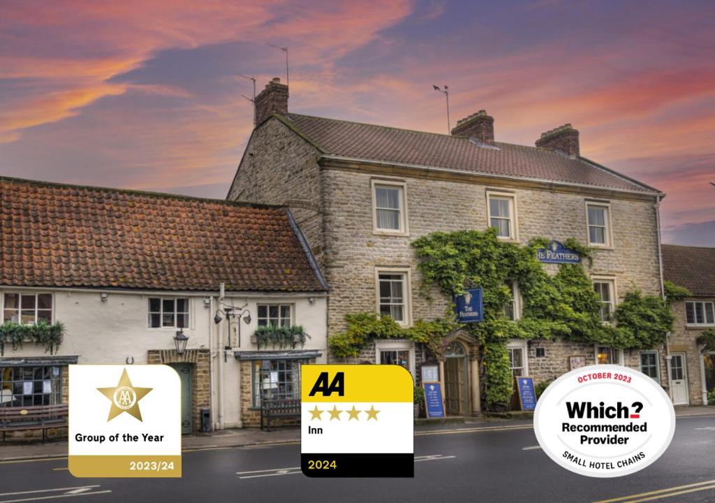 un edificio con una señal delante de él en The Feathers Hotel, Helmsley, North Yorkshire en Helmsley