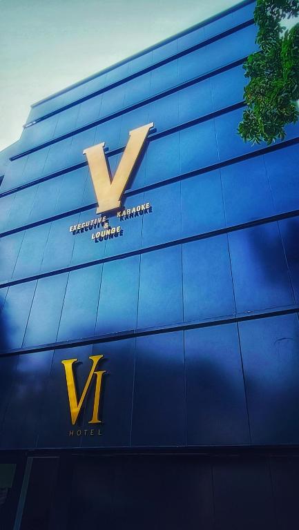 um sinal no lado de um edifício azul em VI Hotel Bandung em Bandung