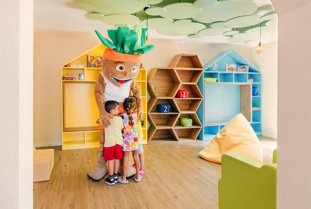a boy and two children standing next to a giant statue at Hotel Jardín Tecina in Playa de Santiago