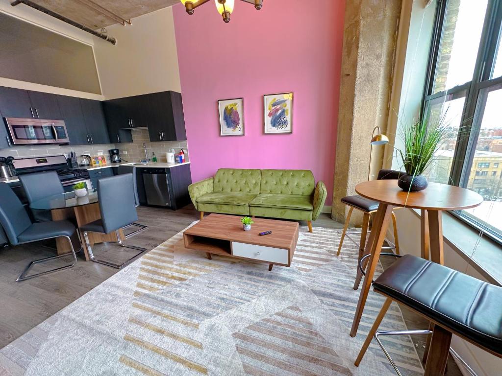 a living room with a green couch and a table at McCormick Place modern loft with an amazing city skyline view and optional parking for 6 guests in Chicago