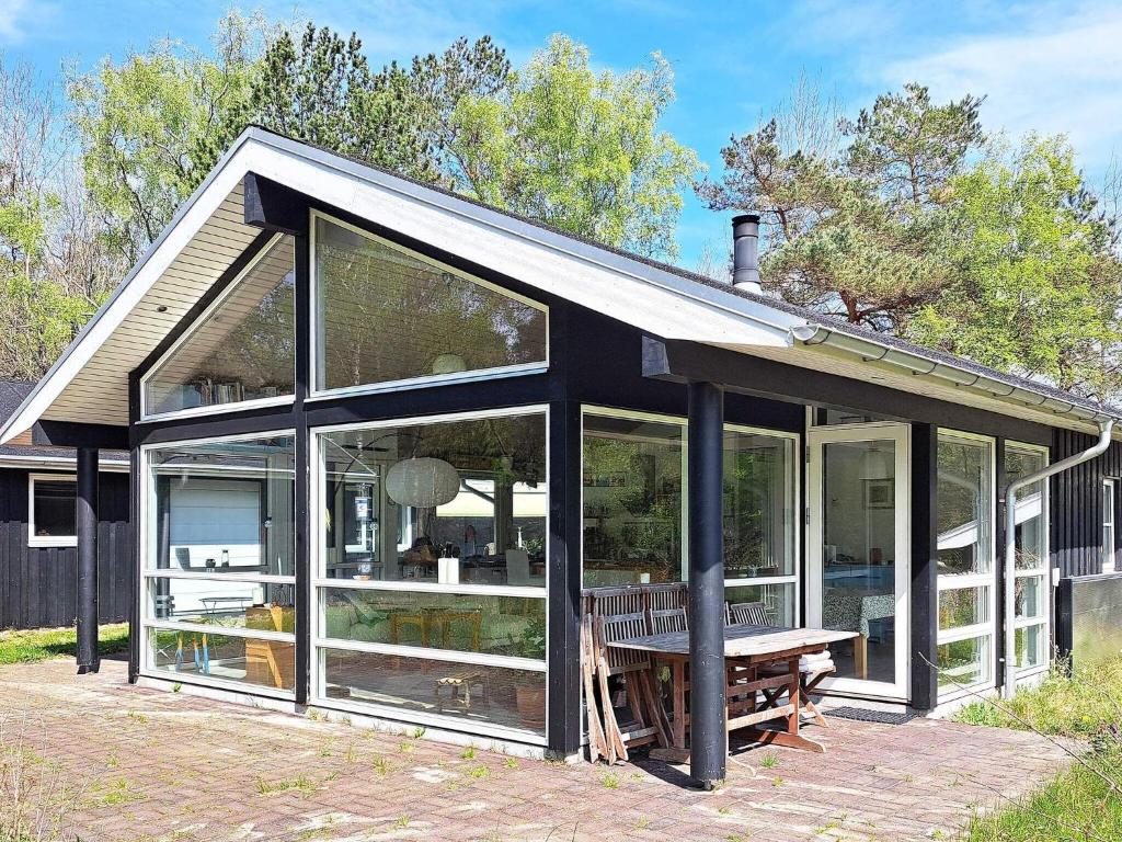 a house with large glass windows and a bench at 8 person holiday home in Hadsund in Hadsund