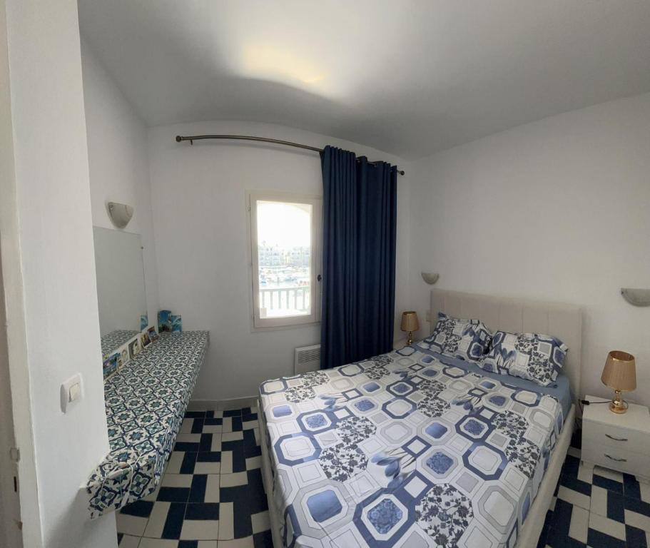 1 dormitorio con cama y ventana en Bel appartement au coeur du Port El Kantaoui, en Port El Kantaoui