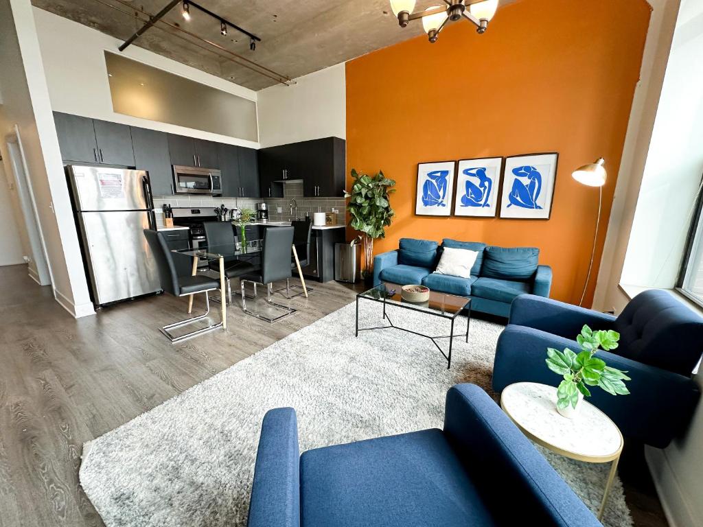 a living room with blue couches and a kitchen at McCormick Place 2b-2b family unit with optional parking sleeps up to 6 in Chicago