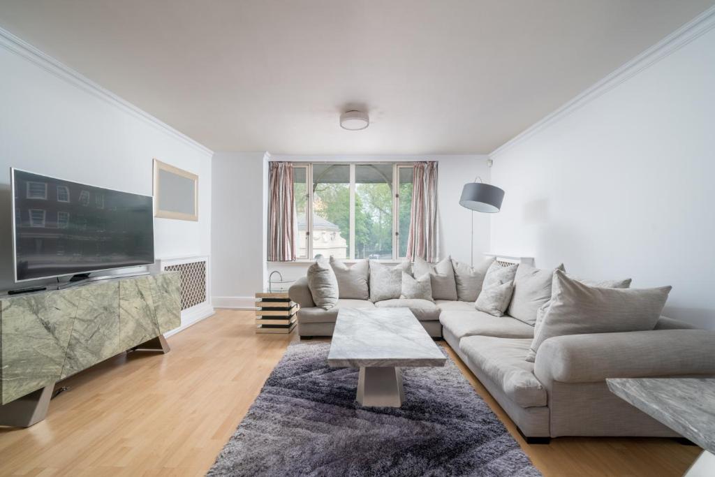 倫敦的住宿－Luxury St Johns Wood 2-bed with 24hr Concierge，带沙发和电视的白色客厅