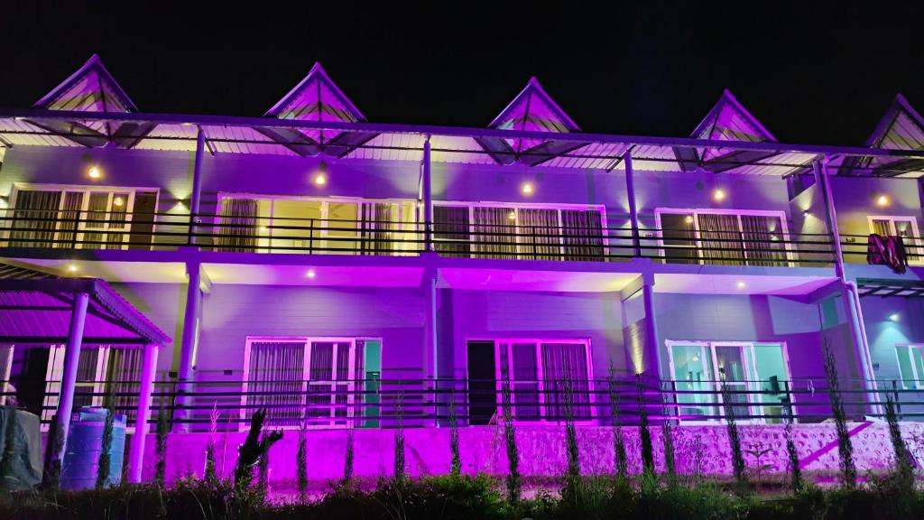 una casa iluminada en púrpura por la noche en MAAKOT HOMESTAY en Nainital