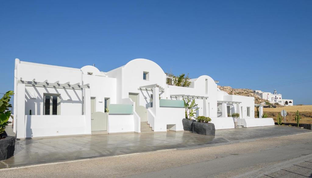 eine Reihe weißer Gebäude an der Straßenseite in der Unterkunft Aegean Diamonds Luxury Suites in Monolithos