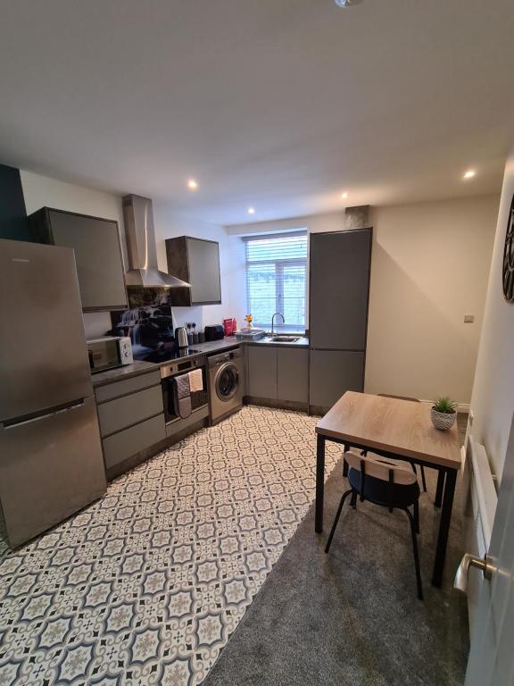 a kitchen with a wooden table and a table sidx sidx sidx at Cosy Mytholmroyd Getaway in Mytholmroyd