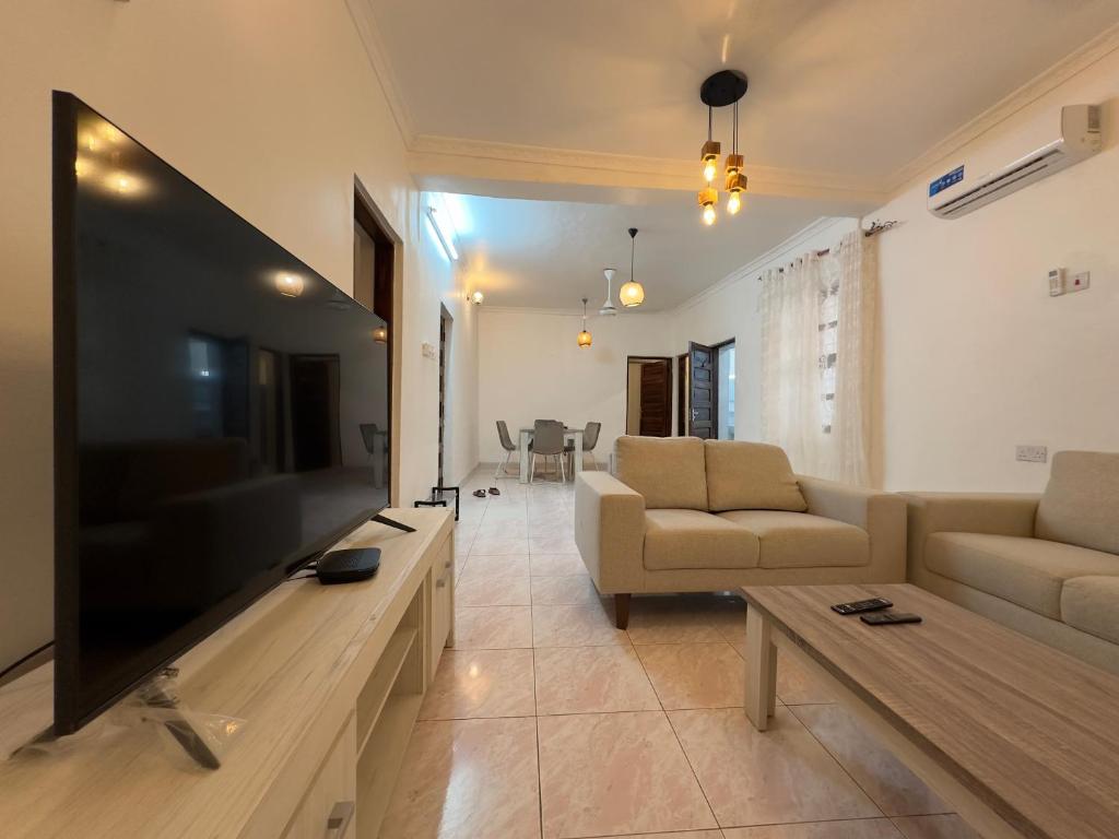 Mokawa BnB Stone Town في Ngambo: غرفة معيشة مع تلفزيون بشاشة مسطحة كبيرة