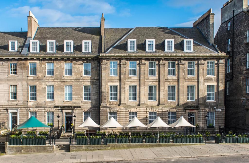 an old building with white umbrellas in front of it at Courtyard by Marriott Edinburgh in Edinburgh