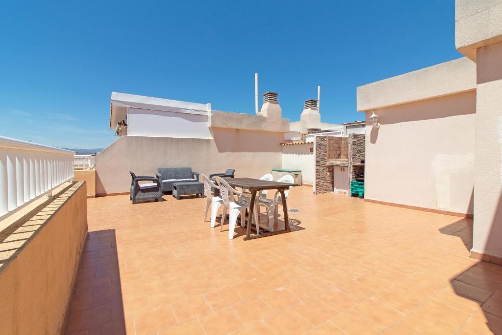 a patio with a table and chairs on a roof at Global Properties, Apartamento con terraza de 70m y piscina en Canet de Berenguer in Canet de Berenguer