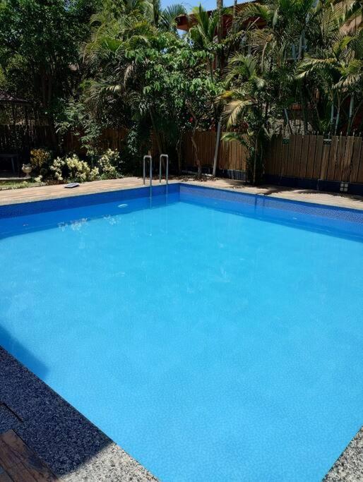 a large blue swimming pool sitting next to a fence at Misty Palace Luxury Villa by Natura Stays in Lonavala