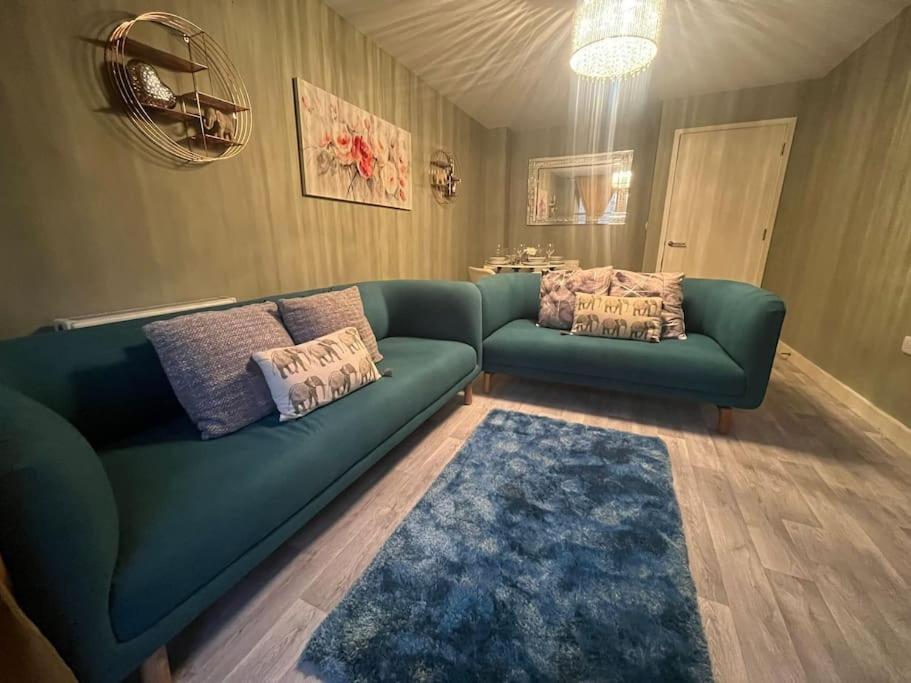 Kent的住宿－BridgeCity 3 bedroom Canning House Maidstone w Parking，客厅配有绿色沙发和蓝色地毯。