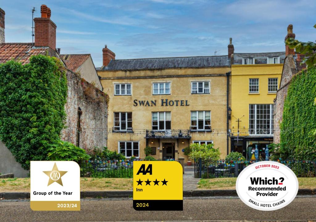 un gran edificio amarillo con un cartel delante en The Swan Hotel, Wells, Somerset, en Wells