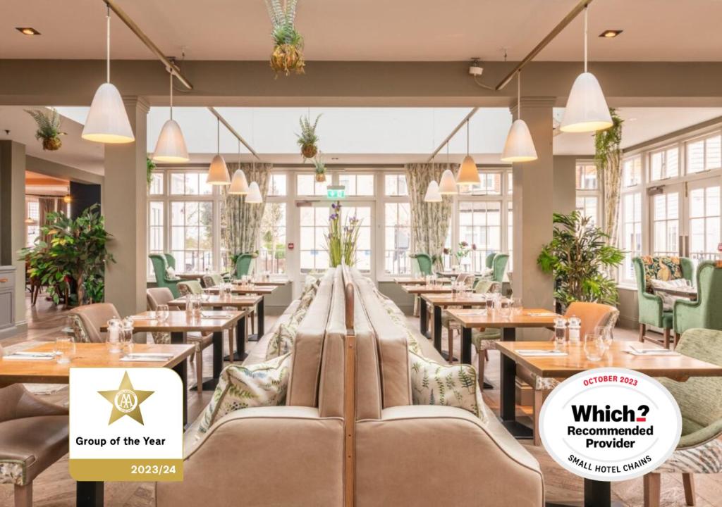 un restaurante con mesas, sillas y ventanas en The Royal Wells Hotel en Royal Tunbridge Wells