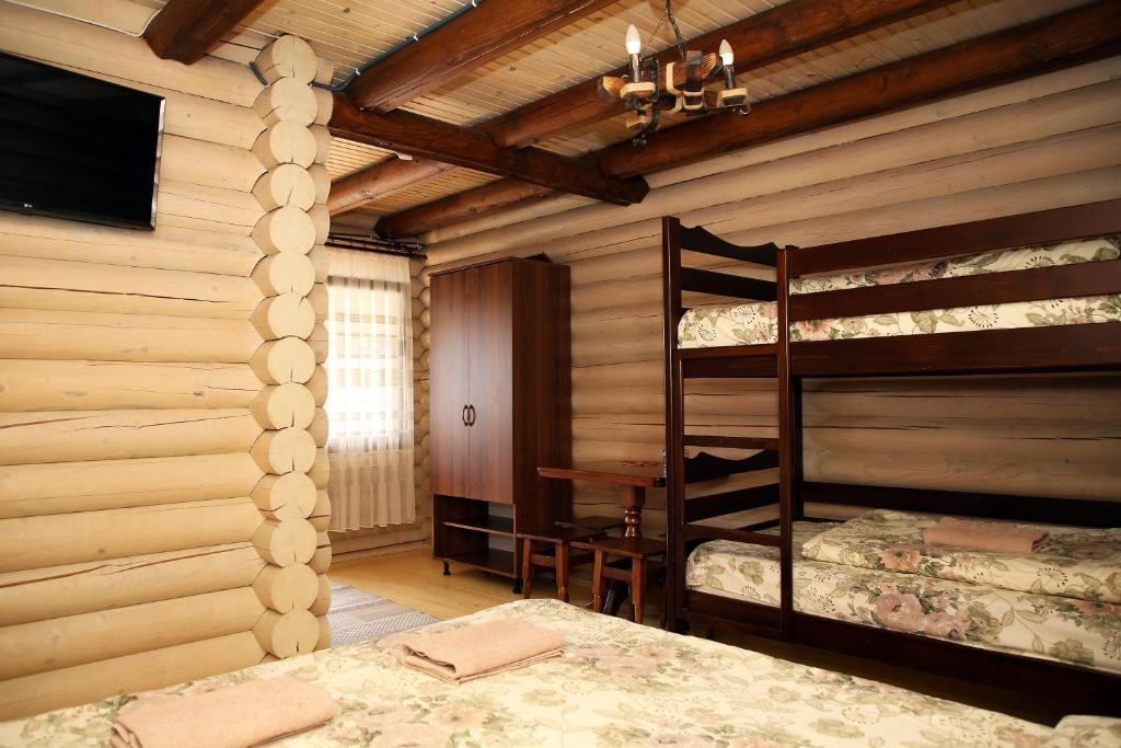 a bedroom with two bunk beds in a log cabin at Соляний Кристал in Solotvyno