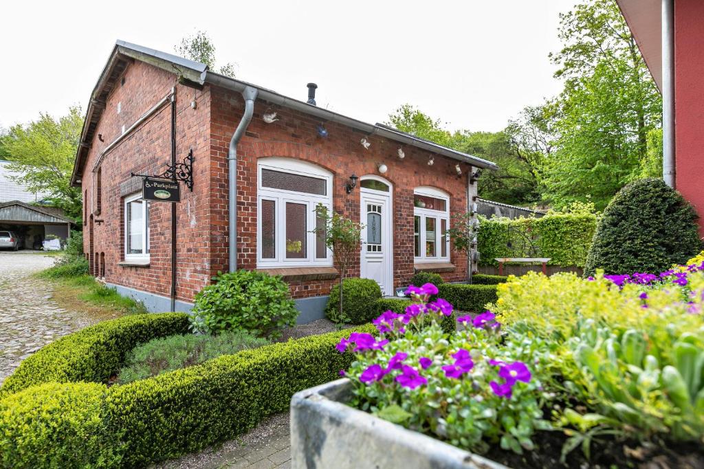 a brick house with flowers in front of it at Ferienwohnung Kaffeemühle in Flensburg
