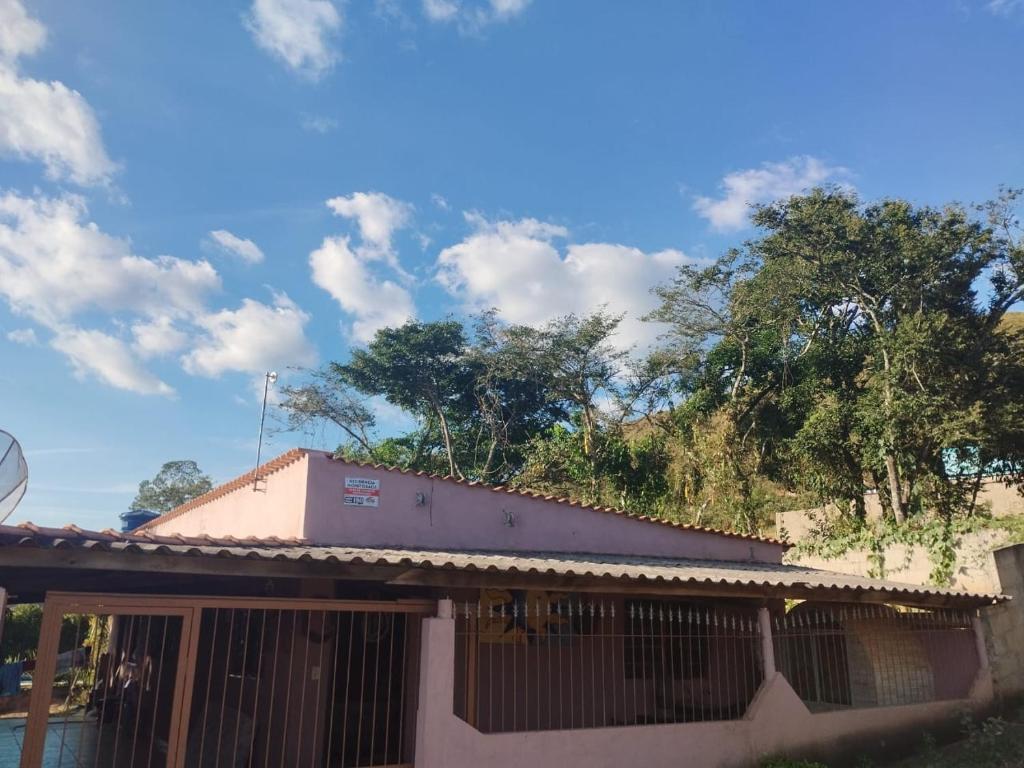 ein Haus mit einem Zaun und Bäumen im Hintergrund in der Unterkunft BiaMar in Luminárias