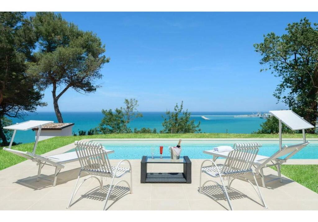 2 sillas y una mesa junto a la piscina en Villa Krizia, en Ancona